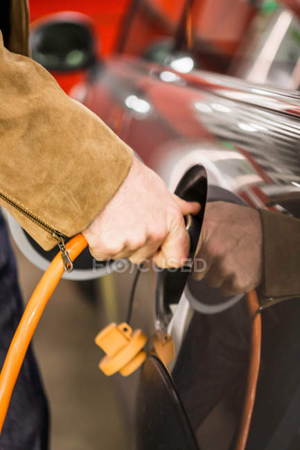 Обрізане зображення людини, що заповнює газовий бак автомобіля — стокове фото