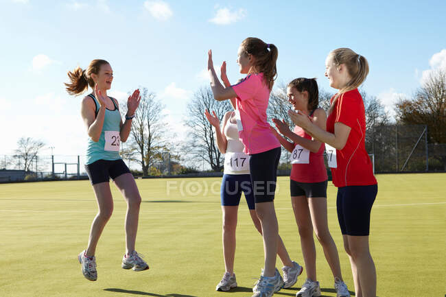 Runners cheering together in field — Stock Photo