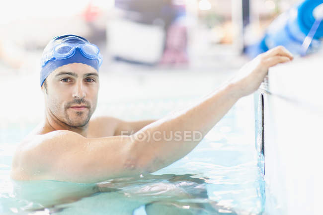 Swimmer climbing out of pool — Stock Photo