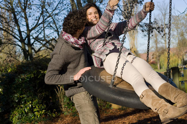 Couple having on fun on swing — Stock Photo