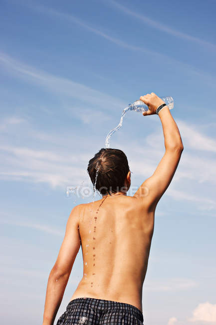 Хлопчик-підліток наливає воду на себе — стокове фото