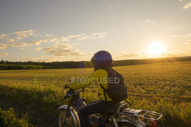Boy riding bicycle through field — Stock Photo