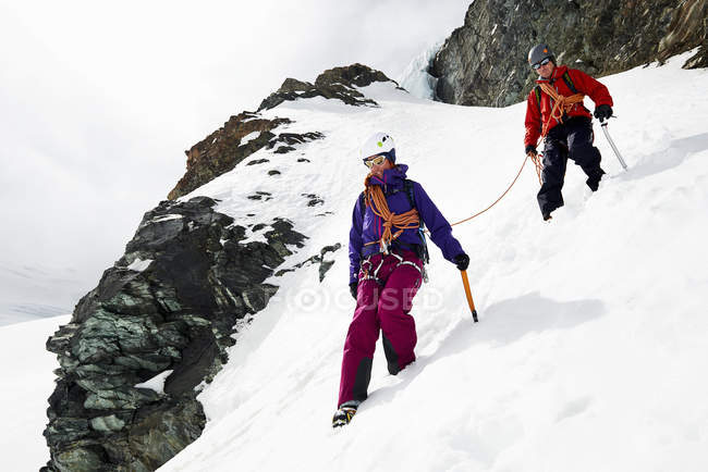Montañeros descendiendo montaña cubierta de nieve, Saas Fee, Suiza - foto de stock