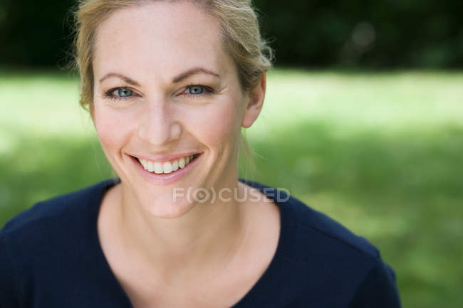 Close up de mulher sorridente olhando para a câmera — Fotografia de Stock