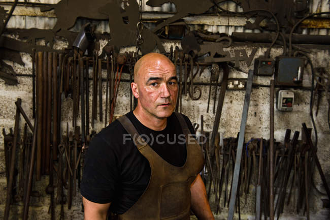 Мужской кавказский кузнец за работой в мастерской — стоковое фото