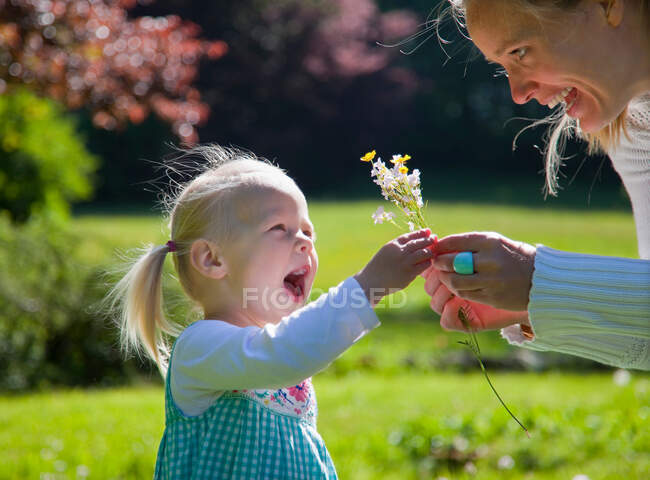Mãe entregando a filha ramo de flores — Fotografia de Stock
