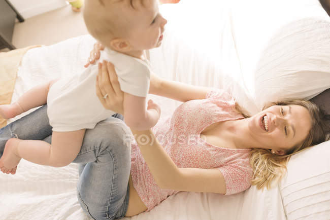 Мать и ребенок сближаются на кровати дома — стоковое фото