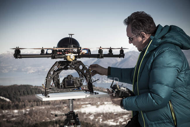 Mature man preparing to fly drone, Stresa, Piedmont, Italy — Stock Photo