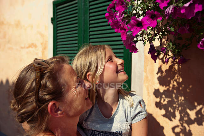 Мати і дочка захоплюються квітами, зосередьтеся на передньому плані — стокове фото
