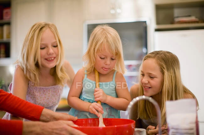 Hermanas cocinando juntas en la cocina - foto de stock