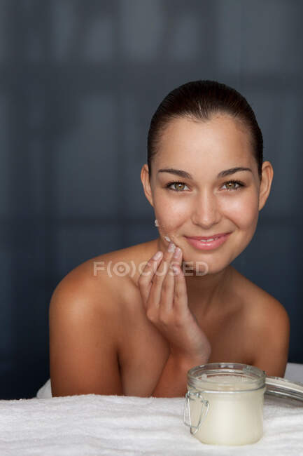 Woman scrubbing her face with sugar — Stock Photo