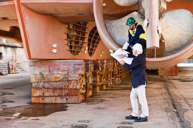 Workers talking in propeller on dry dock — Stock Photo