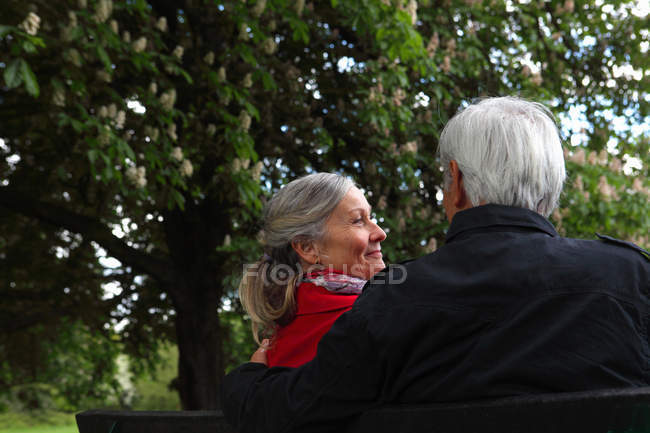 Літня пара сидить на лавці парку — стокове фото