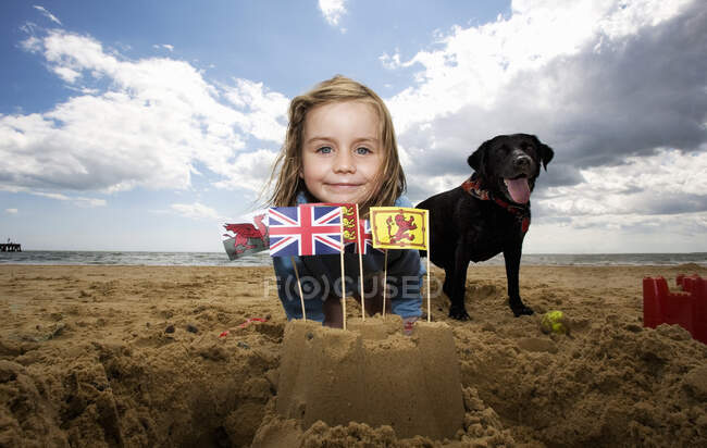Молода дівчина на пляжі з піщаним замком, Вальберсвік, Саффолк, Англія, Велика Британія. — стокове фото
