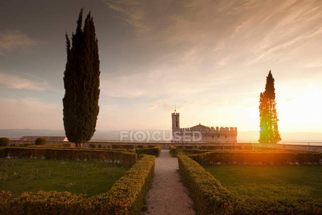 Manicured garden bushes overlooking castle at sunset — Stock Photo