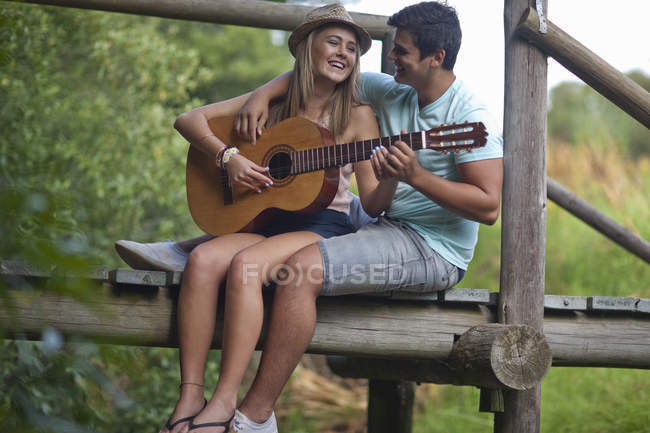 Couple adolescent jouant de la guitare et chantant — Photo de stock