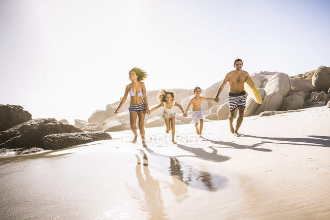 Parents and two children running on beach, Cape Town, South Africa — Stock Photo
