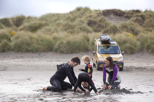 Сім'я з двома хлопчиками, які грають на пляжі — стокове фото