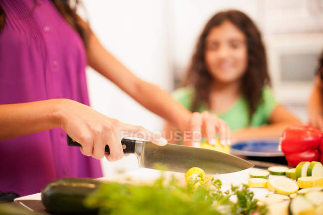 Close up of woman slicing vegetables — Stock Photo