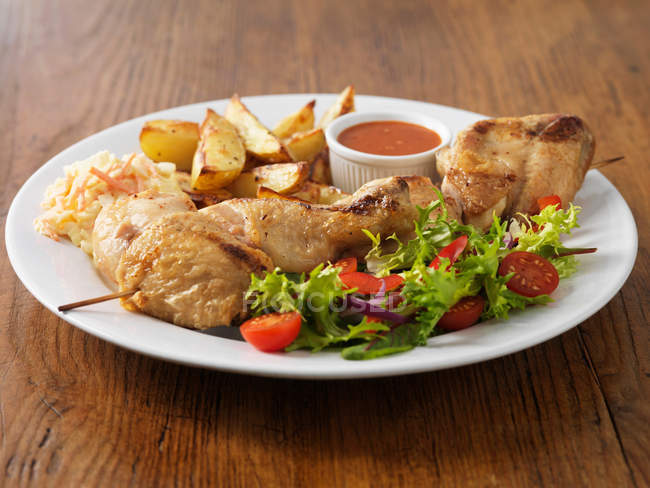 Plate of chicken with salad and potatoes — Stock Photo