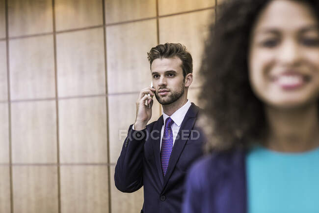 Молодой бизнесмен разговаривает по смартфону в офисе — стоковое фото