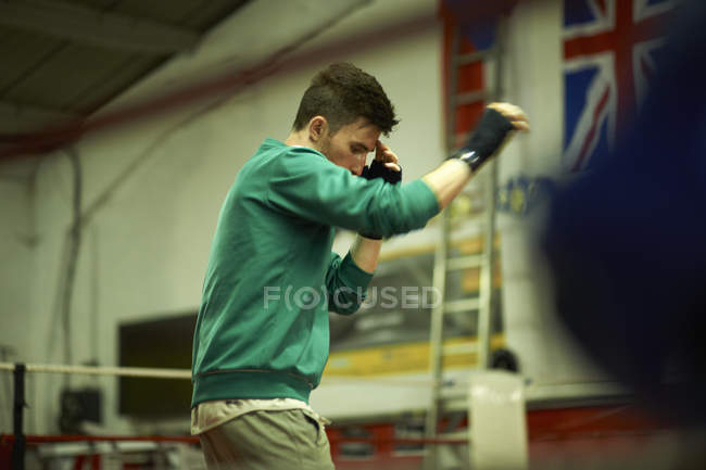 Boxeador practicando en el ring de boxeo - foto de stock