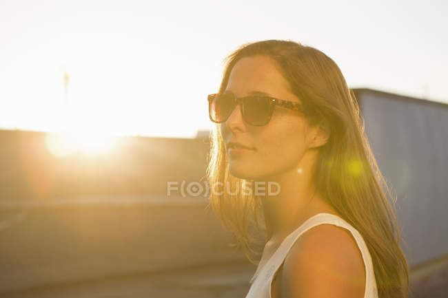 Retrato de jovem mulher usando óculos de sol — Fotografia de Stock