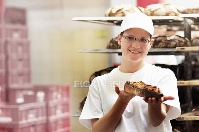 Baker holding fresh bread — Stock Photo