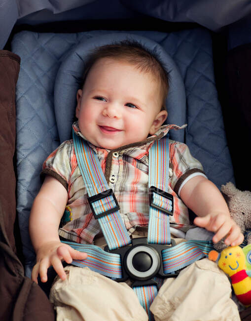 Un bambino nel suo seggiolino sorridente — Foto stock