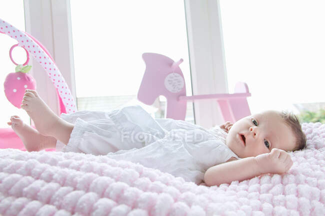 Bebê menina deitada na cama — Fotografia de Stock