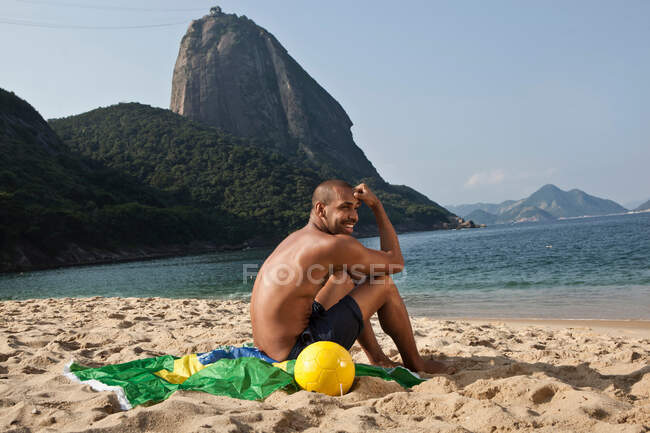 Homme assis sur la plage, Rio de Janeiro, Brésil — Photo de stock