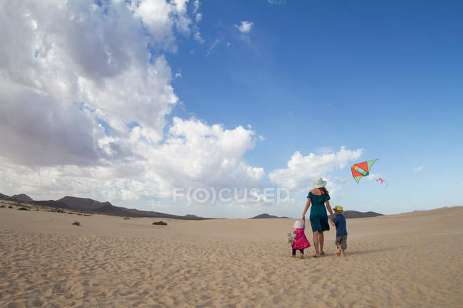 Rückansicht einer Familie, die gemeinsam am Strand spazieren geht — Stockfoto