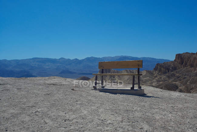 Bench on path in mountains — Stock Photo