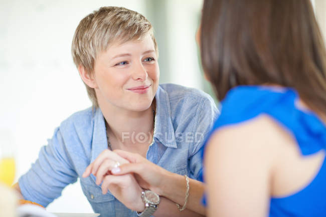 Smiling lesbian couple holding hands — Stock Photo