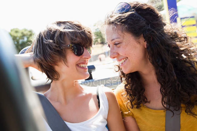 Frauen lächeln zusammen im Cabrio, konzentrieren sich auf den Vordergrund — Stockfoto