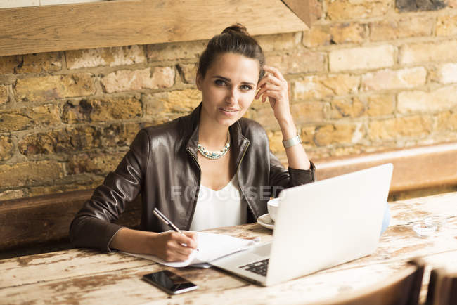 Portrait de jeune femme d'affaires prenant des notes dans un café — Photo de stock