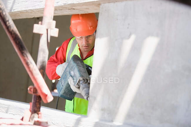 Building worker handling a drill — Stock Photo