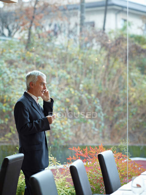 Homme d'affaires parlant sur le smartphone dans Restaurant — Photo de stock