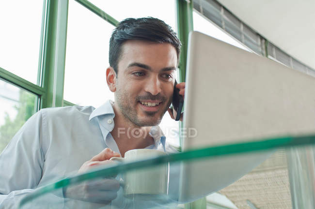 Jeune employé de bureau masculin parlant sur téléphone mobile — Photo de stock