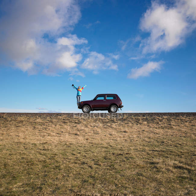 Жінка стоїть на джипі на сільській дорозі — стокове фото