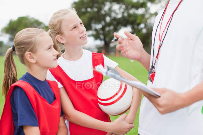 Тренер розмовляє з дітьми про футбольну команду — стокове фото