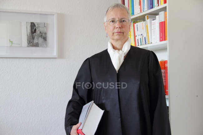 Lawyer holding text book in office — Stock Photo