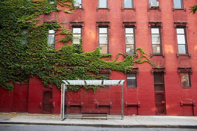Автобусна зупинка та будівля з червоної цегли — стокове фото