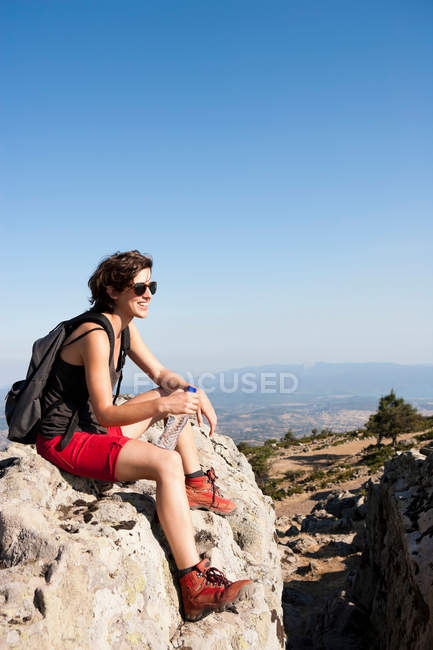 Wanderer ruht sich auf Felsen auf Hügel aus — Stockfoto