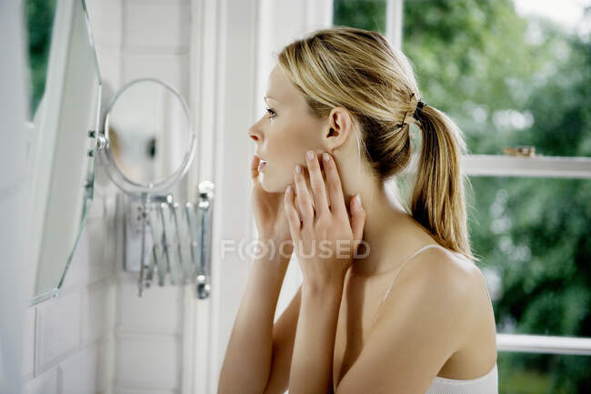 Woman looking in mirror. — Stock Photo