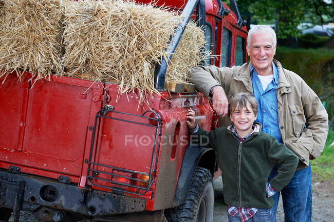 Abuelo y nieto por 4x4 en la granja - foto de stock