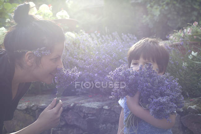 Mother and toddler son smelling bunches of lavender — Stock Photo