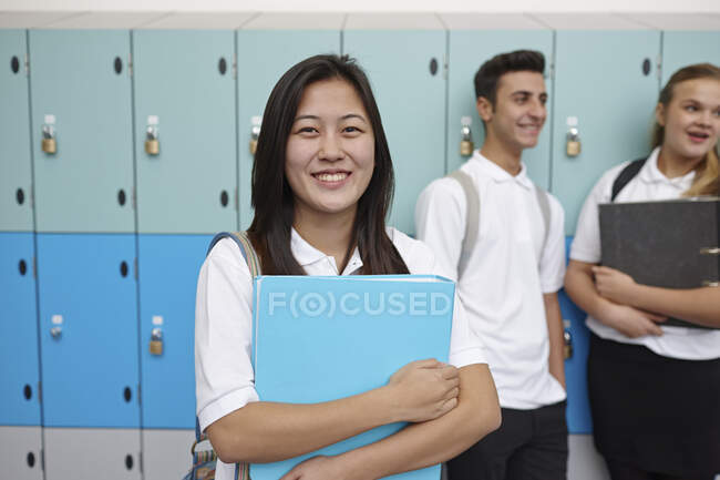Portrait of teenage schoolgirl next to lockers — Stock Photo