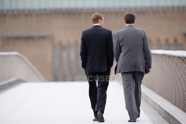 Businessmen walking on bridge together — Stock Photo