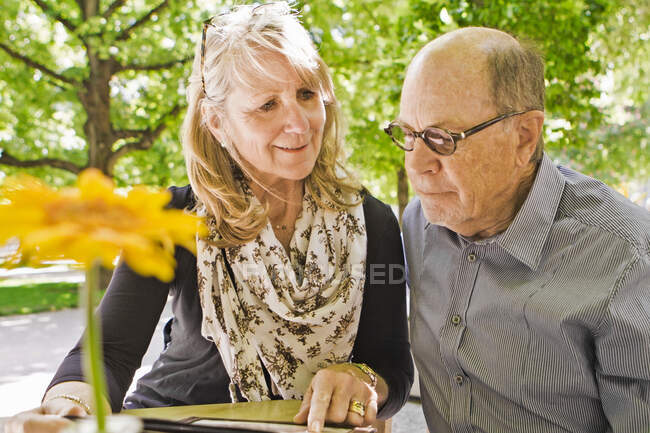 Menú de lectura para parejas mayores en la cafetería - foto de stock